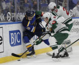 St. Louis Blues' Robert Thomas (18) battles for the loose puck along the boards with Minnesota Wild's Jared Spurgeon (46) and Ryan Suter (20) in the second period of an NHL hockey game, Wednesday, May 12, 2021 in St. Louis. (AP Photo/Tom Gannam)