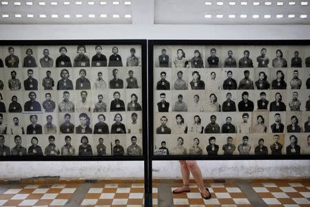 A visitor looks at pictures of victims of Khmer Rouge regime at the former notorious Tuol Sleng prison that is now the Genocide Museum, in Phnom Penh August 5, 2014. REUTERS/Damir Sagolj