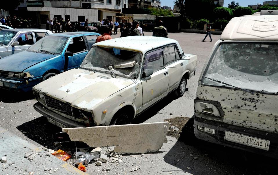 In this photo which AP obtained from the Syrian official news agency SANA, and has been authenticated based on its contents and other AP reporting, damages are seen after a series of mortar shells hit Damascus, killing more than a dozen people and wounding scores in Syria, Tuesday, April 29, 2014. The attacks in the Syrian capital came a day after President Bashar Assad announced his candidacy for the June 3 presidential election. (AP Photo/SANA)