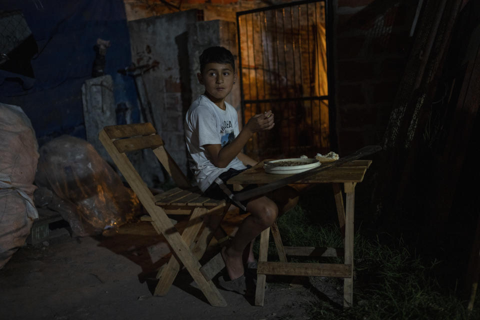 Tiziano, 10, eats dinner at a soup kitchen in Puerta 8, a low income neighborhood north of Buenos Aires, Argentina, Wednesday, Feb. 9, 2022, where contaminated cocaine may have been sold. A batch of that toxic cocaine has killed at least 23 people and hospitalized many more, according to police. (AP Photo/Rodrigo Abd)