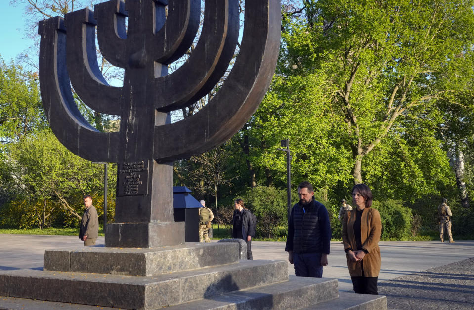 German foreign minister Annalena Baerbock and Deputy Minister for Foreign Affairs of Ukraine Mykola Tochytskyi mourn at the Menorah monument in Babi Yar ravine, where Nazi troops machine-gunned many thousands of Jews during WWII, in Kyiv, Ukraine, Tuesday, May 10, 2022. (AP Photo/Efrem Lukatsky)