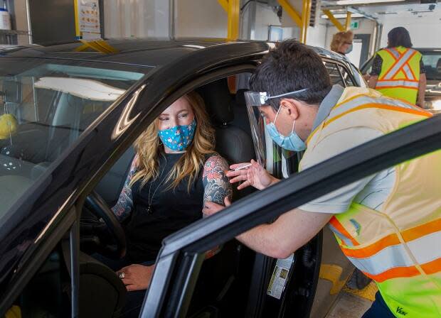 Kelly Clark receives the Pfizer-BioNTech COVID-19 vaccine from registered nurse Kevin Orrell at Nova Scotia's first drive-thru vaccination clinic at the Dartmouth General Hospital in May. The clinic will begin accepting drop-ins on Saturday. (Andrew Vaughan/The Canadian Press - image credit)