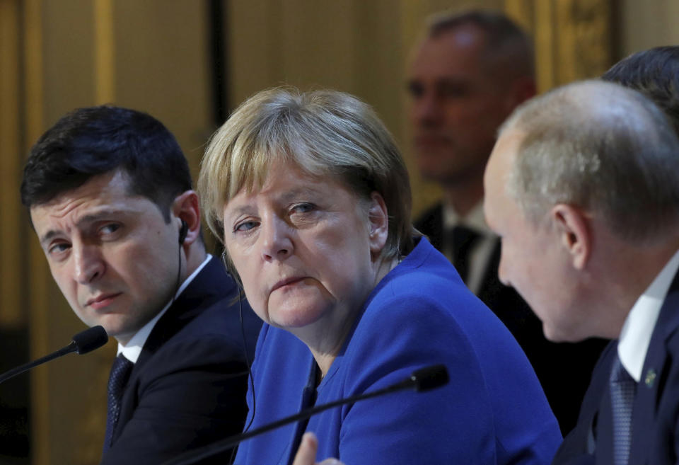 Ukraine's President Volodymyr Zelenskiy, left, German Chancellor Angela Merkel and Russian President Vladimir Putin, right, attend a joint news conference with French President Emmanuel Macron at the Elysee Palace in Paris, Monday Dec. 9, 2019. Russian President Vladimir Putin and Ukrainian President Volodymyr Zelenskiy met for the first time Monday at a summit in Paris to try to end five years of war between Ukrainian troops and Russian-backed separatists. (Charles Platiau/Pool via AP)