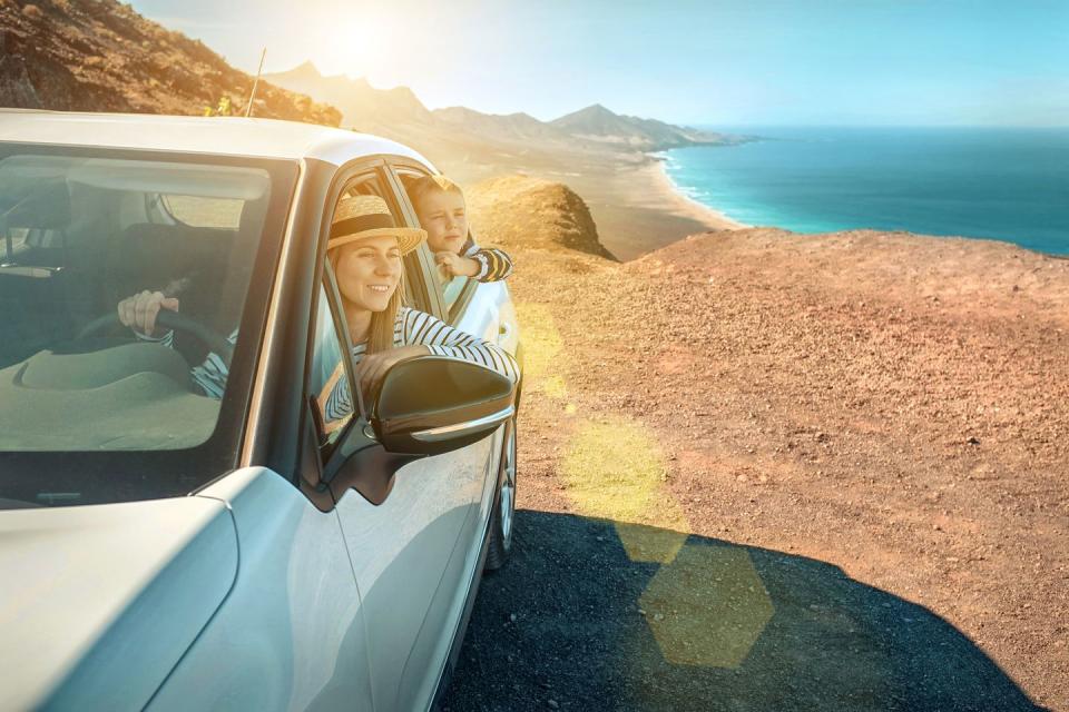 summer activities mother and son sitting in a car and looking out of the window at the beautiful ocean coastline view