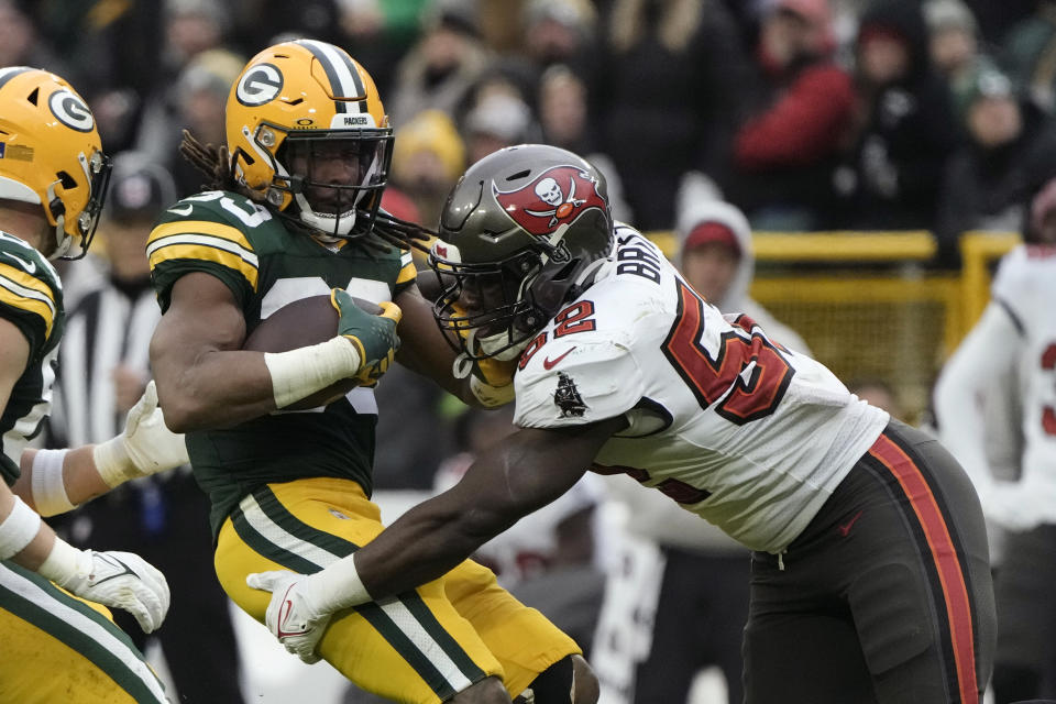 Green Bay Packers running back Aaron Jones (33) is tackled by Tampa Bay Buccaneers linebacker K.J. Britt (52) after catching a pass during the second half of an NFL football game, Sunday, Dec. 17, 2023, in Green Bay, Wis. (AP Photo/Morry Gash)