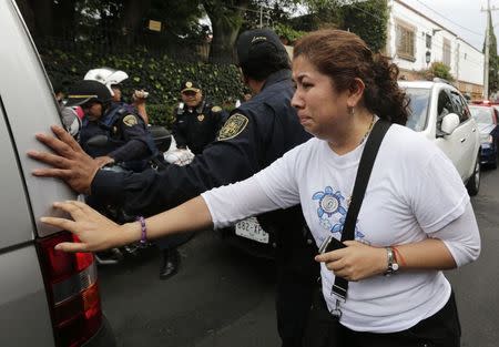 A woman mourns while touching a hearse that left the home of Colombian Nobel Prize laureate Gabriel Garcia Marquez in Mexico City April 17, 2014.