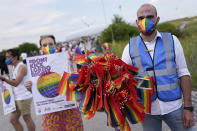 A man offers LGBT pride flags to football supporters outside the stadium before the Euro 2020 soccer championship group F match between Germany and Hungary at the Allianz Arena in Munich, Germany,Wednesday, June 23, 2021. (AP Photo/Matthias Schrader)