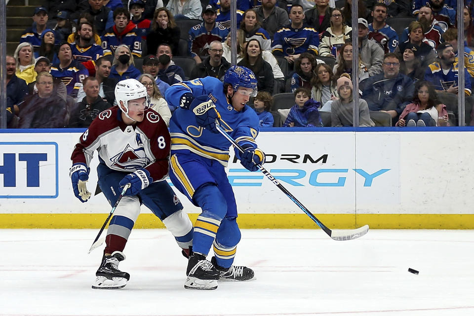 St. Louis Blues' Jake Neighbours (63) takes a short on goal while under pressure from Colorado Avalanche's Cale Makar (8) during the second period of an NHL hockey game Saturday, Feb. 18, 2023, in St. Louis. (AP Photo/Scott Kane)
