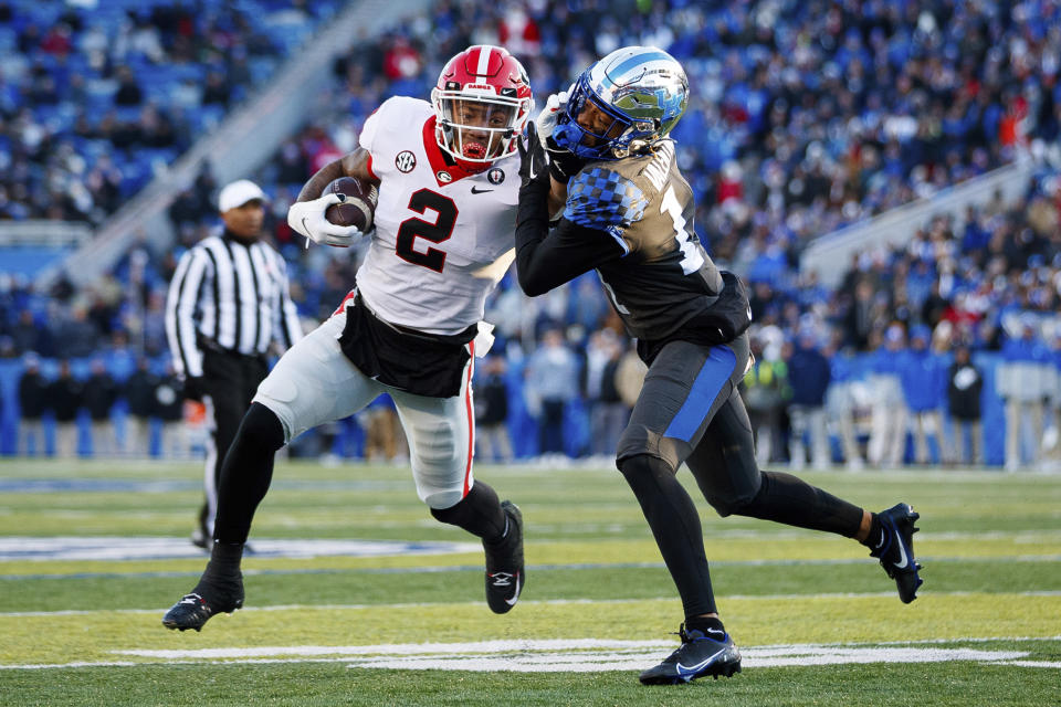 Georgia running back Kendall Milton (2) stiff arms Kentucky defensive back Carrington Valentine (14) during the first half of an NCAA college football game in Lexington, Ky., Saturday, Nov. 19, 2022. (AP Photo/Michael Clubb)