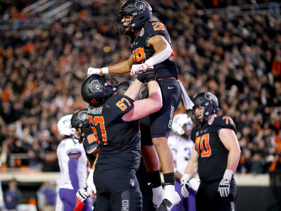 Oklahoma State's Blaine Green (28) celebrates a touchdown in the the second quarter of a 63-17 win against TCU on Nov. 13 at Boone Pickens Stadium in Stillwater.