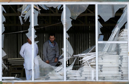 Afghan men look outside a broken window at the site of a suicide attack in Kabul, Afghanistan September 9, 2018.REUTERS/Omar Sobhani