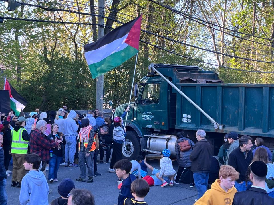 Prrotesters, at left, and supporters of President Biden at right, wait for his motorcade to arrive on Broadway in Irvington during his visit to the village for a fundraising event April 25, 2024.