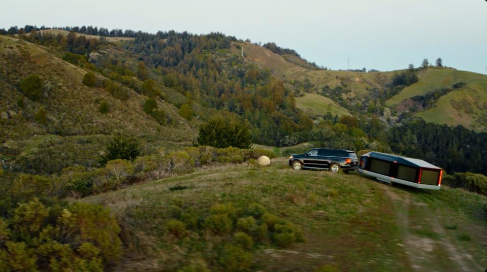 Lightship's electric L1 travel trailer being towed outside in nature.