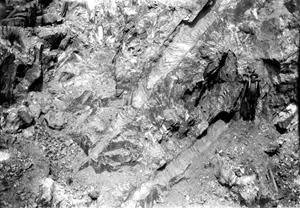 Gigantic crystals of Spodumene (1904) — molds of two immense crystals (for size comparison see mine worker in center of right side of photo). Etta Mines — Black Hills, Pennington County, South Dakota. Plate i-B in U.S. Geological Survey. Bulletin 610. 1916.