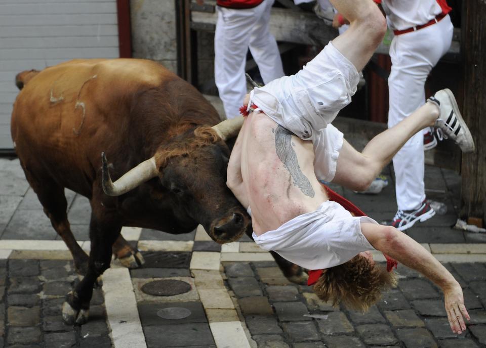 A Jandilla bull charges at a participant during the first 'encierro' (bull-run) of the San Fermin Festival in Pamplona, northern Spain, on July 7, 2015. The festival is a symbol of Spanish culture that attracts thousands of tourists to watch the bull runs despite heavy condemnation from animal rights groups. AFP PHOTO/ ANDER GILLENEA        (Photo credit should read ANDER GILLENEA/AFP/Getty Images)