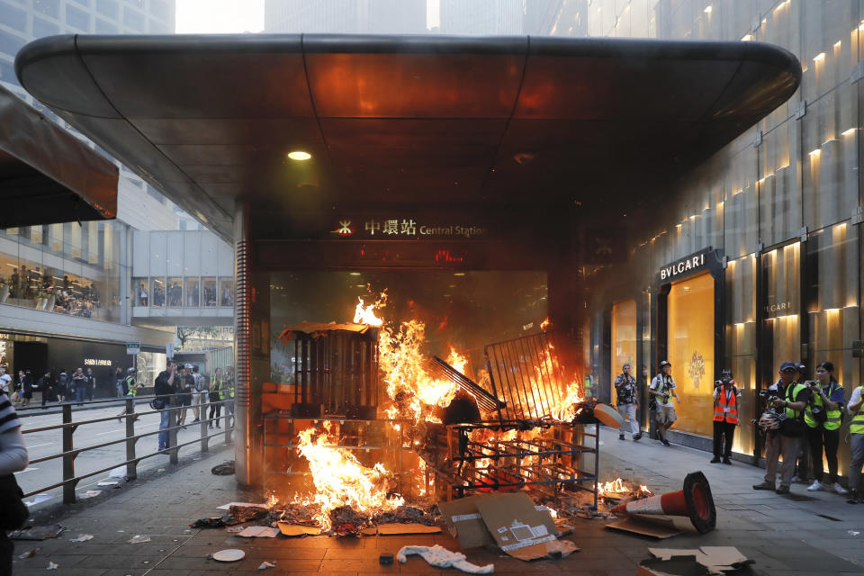 In this Sunday, Sept. 8, 2019, file photo, a fire set by protesters burns at an entrance to the Central MTR subway station in Hong Kong. Thousands of demonstrators participated in a peaceful march to the U.S. Consulate but later violence broke out in the business and retail but later after protesters vandalized a metro station and blocked traffic at a major thoroughfare, with several people detained. (AP Photo/Kin Cheung, File)