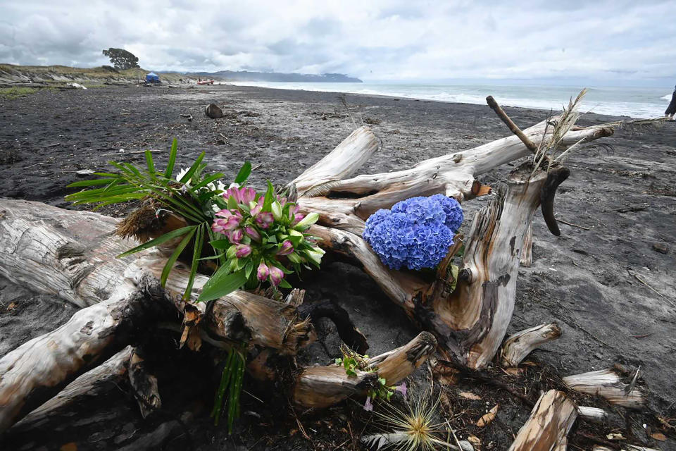 Flowers are placed on a beach following a shark attack at Bowentown near Waihi in New Zealand, Friday, Jan 8, 2021. A woman has died Thursday, Jan. 7, in what appears to be New Zealand's first fatal shark attack in eight years, police say. (George Novak/Bay of Plenty Times via AP)