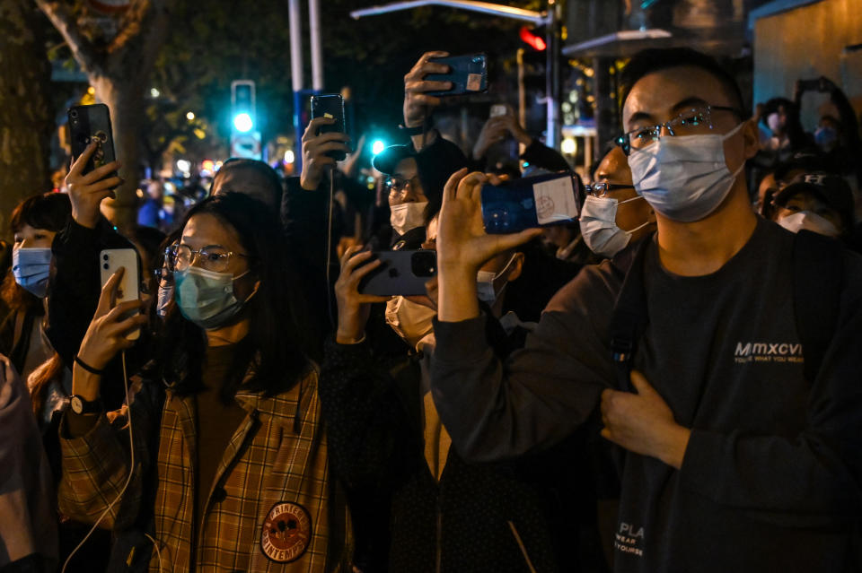 People gather on a street in Shanghai on November 27, 2022, where protests against China's zero-Covid policy took place the night before following a deadly fire in Urumqi, the capital of the Xinjiang region.