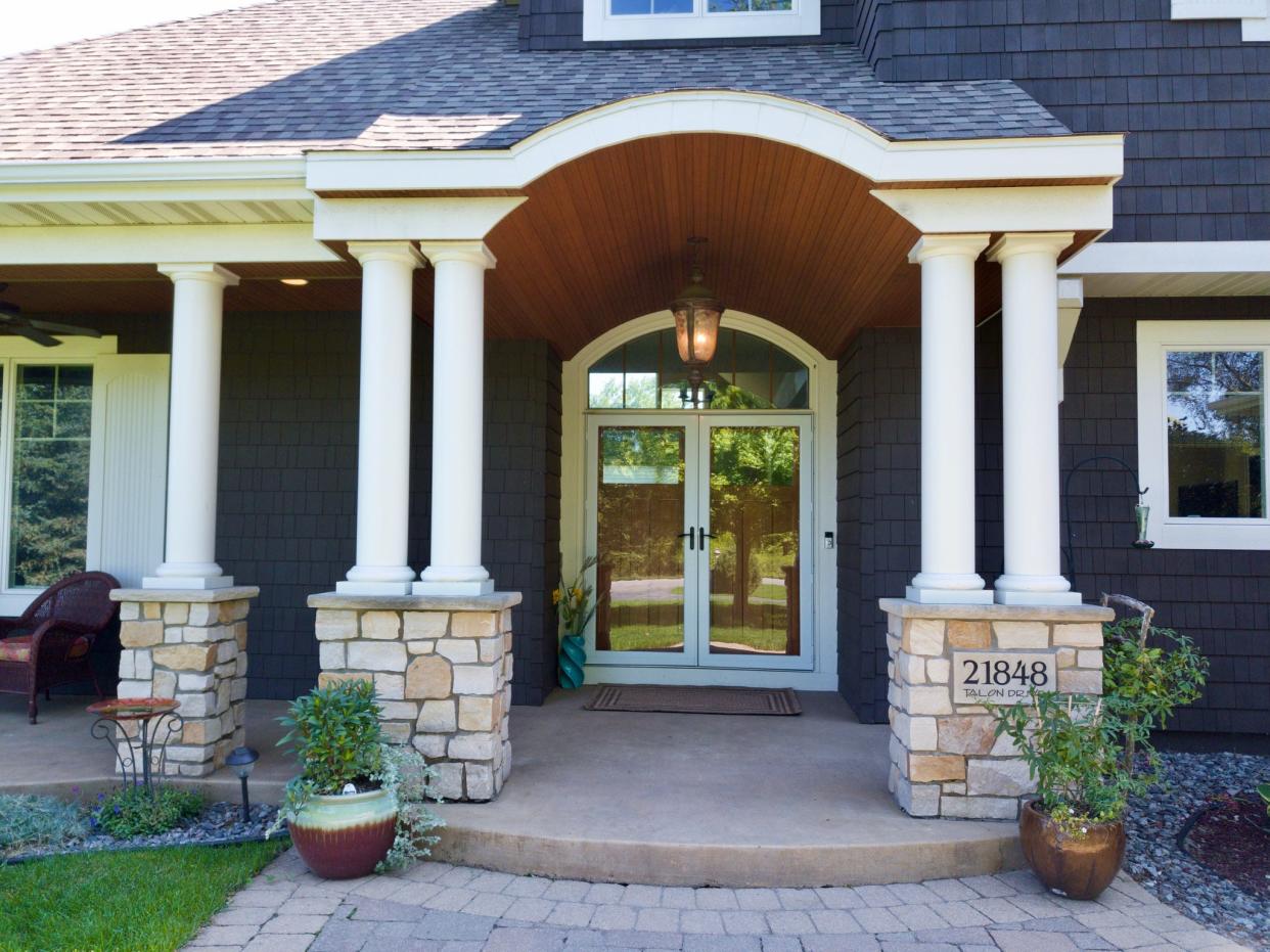 A covered front porch with wood-ceiling detail welcomes family and friends to this more than 5,400 square-foot home.