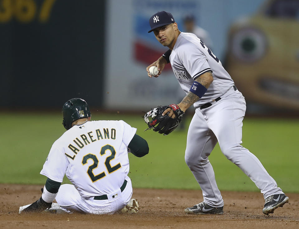 New York Yankees' Gleyber Torres, right, prepares his throw to first base over Oakland Athletics' Ramon Laureano (22) to complete a double play in the third inning of a baseball game Tuesday, Sept. 4, 2018, in Oakland, Calif. A's Jonathan Lucroy was out at first base on the play. (AP Photo/Ben Margot)