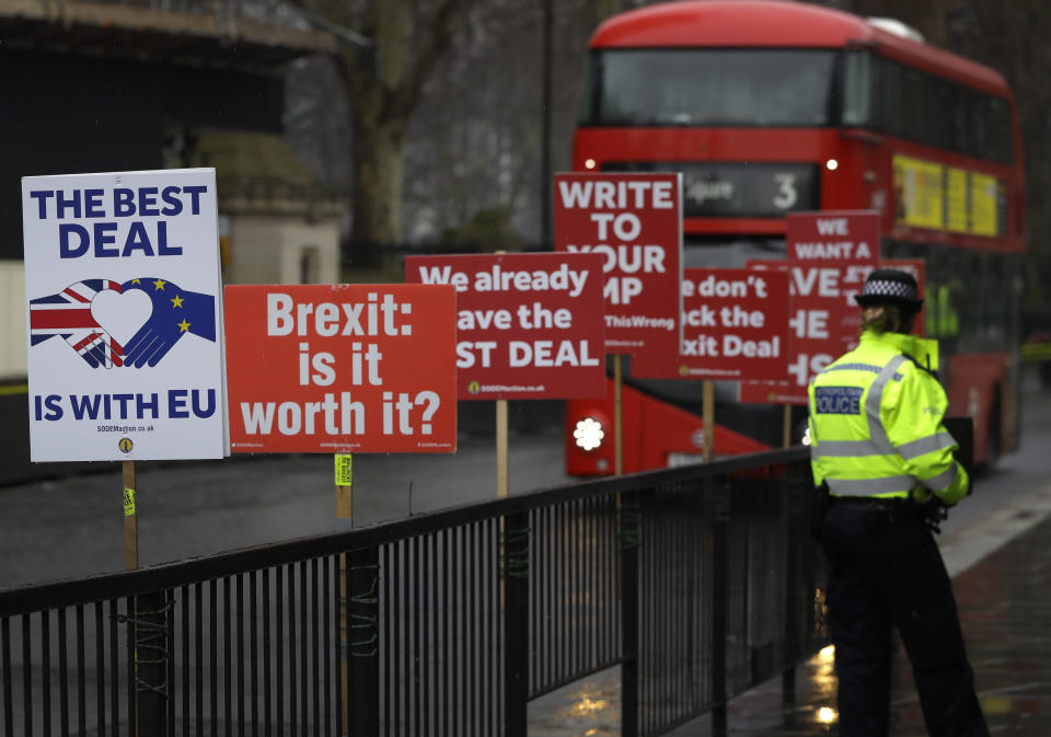 A police officer stands by banners tied to railings outside parliament in London, Thursday, Jan. 24, 2019. The European Union's chief Brexit negotiator, Michel Barnier, is rejecting the possibility of putting a time limit on the "backstop" option for the Irish border, saying it would defeat the purpose. (AP Photo/Kirsty Wigglesworth)