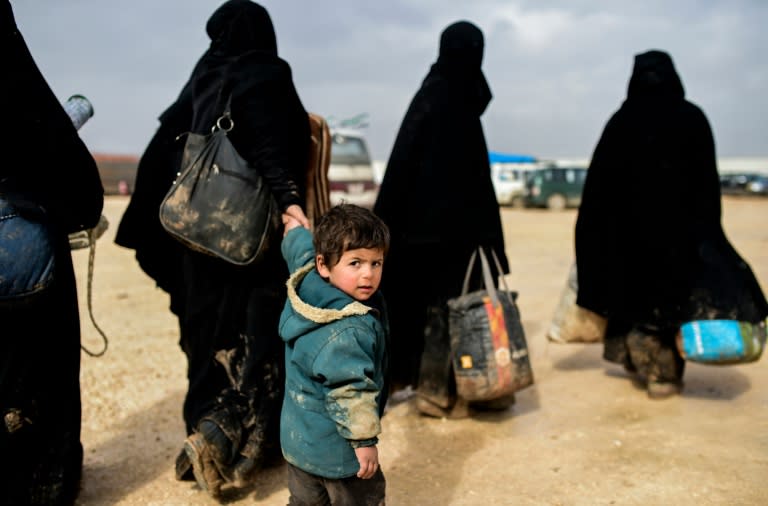 Syrians fleeing Aleppo wait near the border crossing in Bab Al-Salam on February 6, 2016