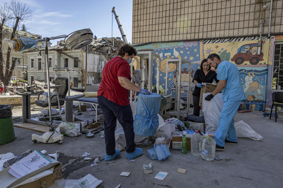 Workers try to salvage intact medical equipment in the hospital yard at the site of Okhmatdyt children's hospital hit by Russian missiles on Monday, in Kyiv, Ukraine, Tuesday, July 9, 2024. (AP Photo/Anton Shtuka)