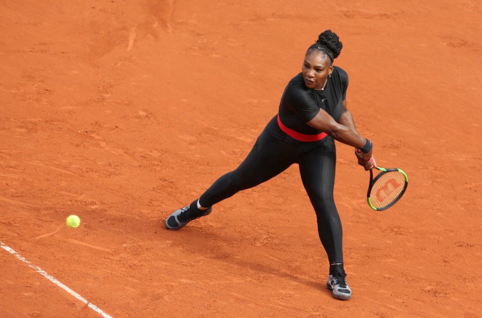 Serena Williams playing tennis in a black catsuit