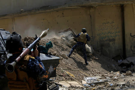 An Iraqi Federal Police member fires towards Islamic State militants during a battle in western Mosul, Iraq, May 28, 2017. REUTERS/Alaa Al-Marjani