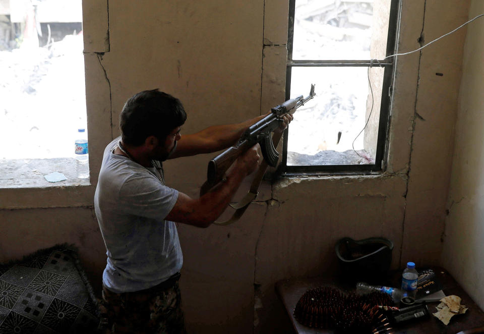 <p>A fighter of the Syrian Democratic Forces fires his weapon towards the positions of the Islamic State militants in the National Hospital, at the frontline in Raqqa, Syria, Oct. 8, 2017. (Photo: Erik De Castro/Reuters) </p>