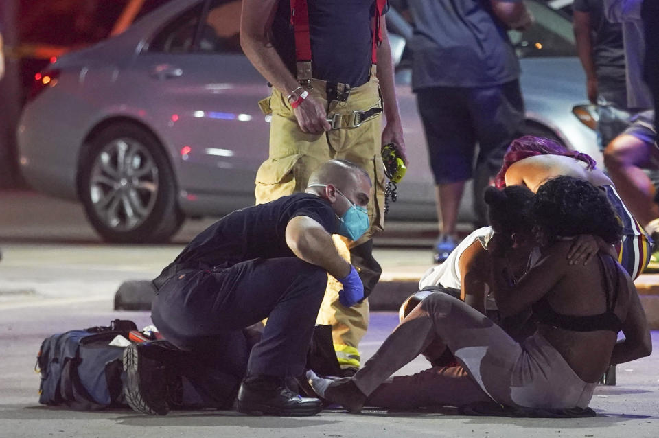 A woman is attended to as the Houston Police Department investigates a fatal shooting at DD Sky Club in Houston on Tuesday, Oct. 20, 2020. (Elizabeth Conley/Houston Chronicle via AP)