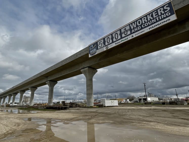 California rail authority banner claims 5,000 workers on the project on a viaduct in Fresno.