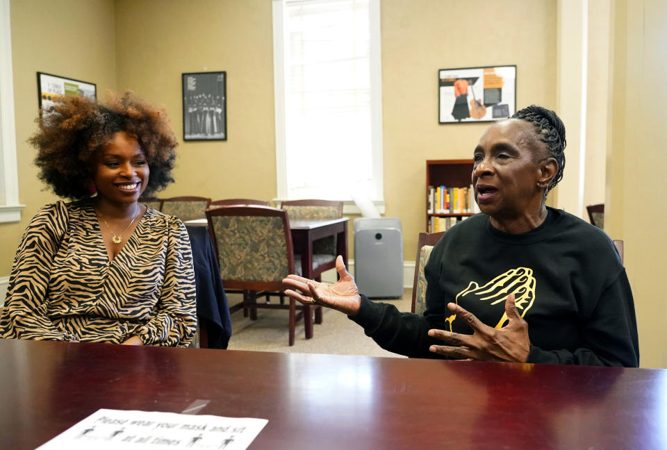 Gloria Green-McCray, right, sister of James Earl Green, who along with Phillip Lafayette Gibbs was killed by Mississippi Highway Patrolmen in 1970 on the campus of Jackson State University, discusses the importance quilting plays in the African American community with Ebony Lumumba, left, department chair and associate professor of English at Jackson State, Tuesday, Nov. 30, 2021, in Jackson, Miss. A cross-stitch portrait of Green is now included with 115 others in the Stitch Their Names Memorial Project, dedicated to memorializing lives lost to racial violence in the U.S. The two quilts are open for public viewing on weekdays through Dec. 17 at Jackson State University’s Margaret Walker Center. (AP Photo/Rogelio V. Solis)