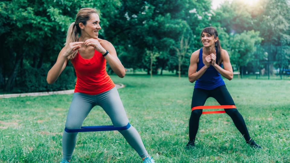 Athletes Exercising With Resistance Bands At Park