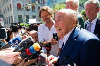 The former Fifa President, Joseph Blatter surrounded by media representatives, waves to the press in front of the Swiss Federal Criminal Court in Bellinzona, Switzerland, at the last day of the trail, after the verdict has been announced, Friday, July 8, 2022. The trial ended with an acquittal. Blatter and Michel Platini, former president of the the European Football Association (Uefa), stood trial before the Federal Criminal Court over a suspicious two-million payment. The Federal Prosecutor's Office accused them of fraud. The defense spoke of a conspiracy. (Ti-Press/Alessandro Crinari/Keystone via AP)