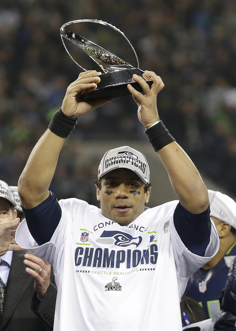 Seattle Seahawks' Russell Wilson holds up the George Halas Trophy after the NFL football NFC Championship game against the San Francisco 49ers Sunday, Jan. 19, 2014, in Seattle. The Seahawks won 23-17 to advance to Super Bowl XLVIII. (AP Photo/Elaine Thompson)