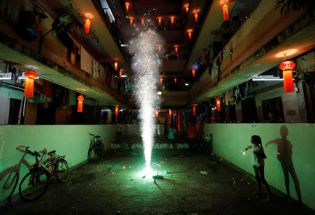 A girl plays with firecrackers while celebrating the Hindu festival of Diwali, the annual festival of lights in Mumbai, October 19, 2017. REUTERS/Danish Siddiqui/Files