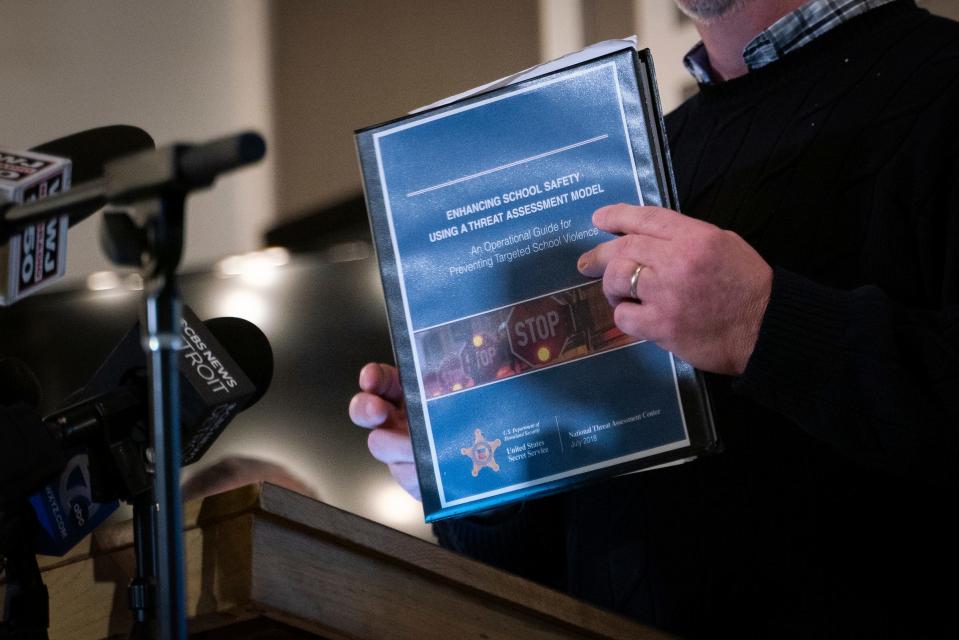 Korey Bailey, former Oxford School Board treasurer, holds a guide for preventing targeted school violence while speaking during a press conference Monday at the Legacy Center in Oxford.