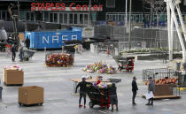 Workers remove thousands of items left in honor of Kobe Bryant, including hundreds of basketballs, from X-Box Plaza across Chick Hearn Court from Staples Center, home of the Los Angeles Lakers, early Monday, Feb. 3, 2020, in Los Angeles. Mourners left the items after the death of the former Lakers legend, his daughter and seven others, in a helicopter crash one week ago. (AP Photo/Reed Saxon)