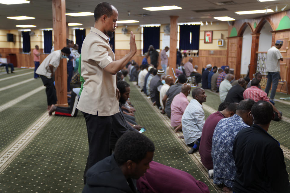 Yusuf Abdulle, standing, director of the Islamic Association of North America, prays with fellow Muslims at the Abubakar As-Saddique Islamic Center in Minneapolis on Thursday, May 12, 2022. This spring Minneapolis became the first large city in the United States to allow the Islamic call to prayer, or adhan, to be broadcast publicly by its two dozen mosques. (AP Photo/Jessie Wardarski)