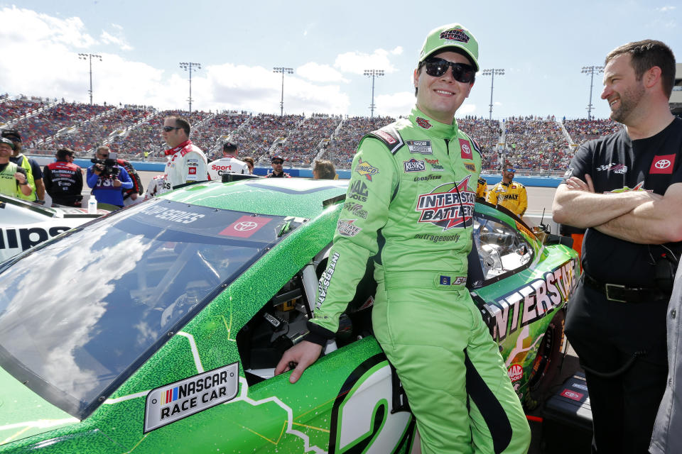 Erik Jones stands next to his race car.