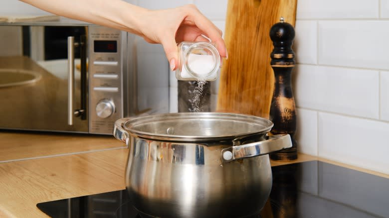 Hand pouring salt into a pot