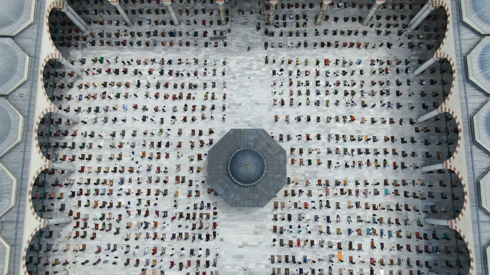 In this aerial photo, worshippers observing social distancing guidelines to protect against coronavirus, attend Friday prayers, outside the Camlica Mosque, the largest mosque in Asia Minor, in Istanbul, Friday, May 29, 2020. The mosque with a capacity under normal circumstances to house 60,000 worshippers, held its first communal Friday prayers in 74 days after the government re-opened some mosques as part of its plans to relax measures in place to fight the coronavirus (COVID-19) outbreak. (Ali Aksoyer/DHA via AP)