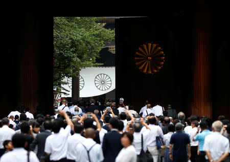 Visitors walk through the main gate of the shrine as the gate is opening at Yasukuni Shrine in Tokyo, Japan August 15, 2017, on the 72nd anniversary of Japan's surrender in World War Two. REUTERS/Issei Kato