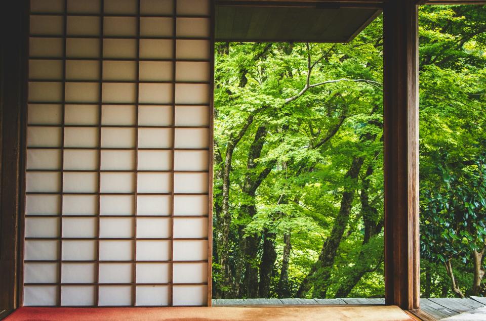 April is one of the best times to visit Japan for wellness experiences. pictured: a traditional Japanese house near lush greenery