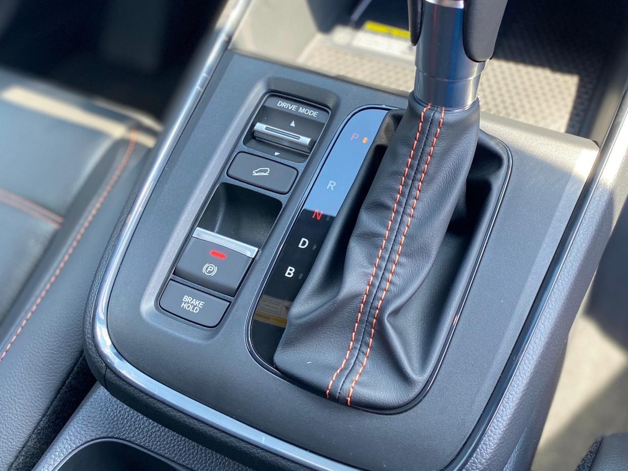 The shifter, parking brake, and drive mode selector on the center console of a 2025 Honda CR-V Hybrid Sport Touring SUV.