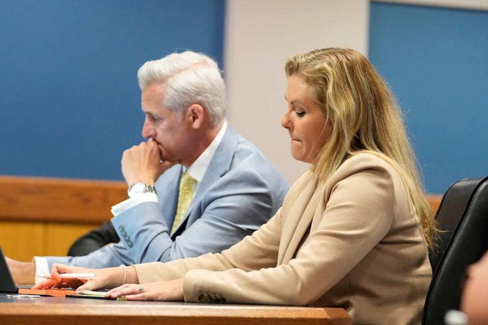 Ashleigh Merchant, right, an attorney for Trump co-defendant Mike Roman, and her husband and law partner John Merchant, left, attend a hearing at the Fulton County courthouse on 27 February (EPA)
