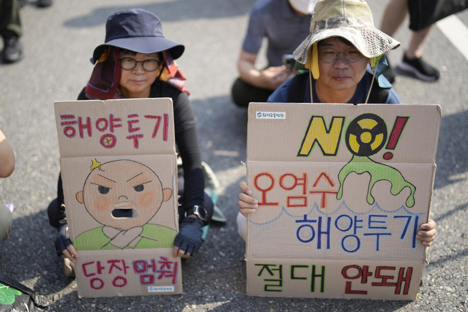 Protesters hold signs during of a rally to demand the stop of the Japan's release of treated radioactive water into the sea from the damaged Fukushima nuclear power plant and denounce the South Korean government's policy in Seoul, South Korea, Saturday, Aug. 26, 2023. The letters read "Oppose to release radioactive water." (AP Photo/Lee Jin-man)