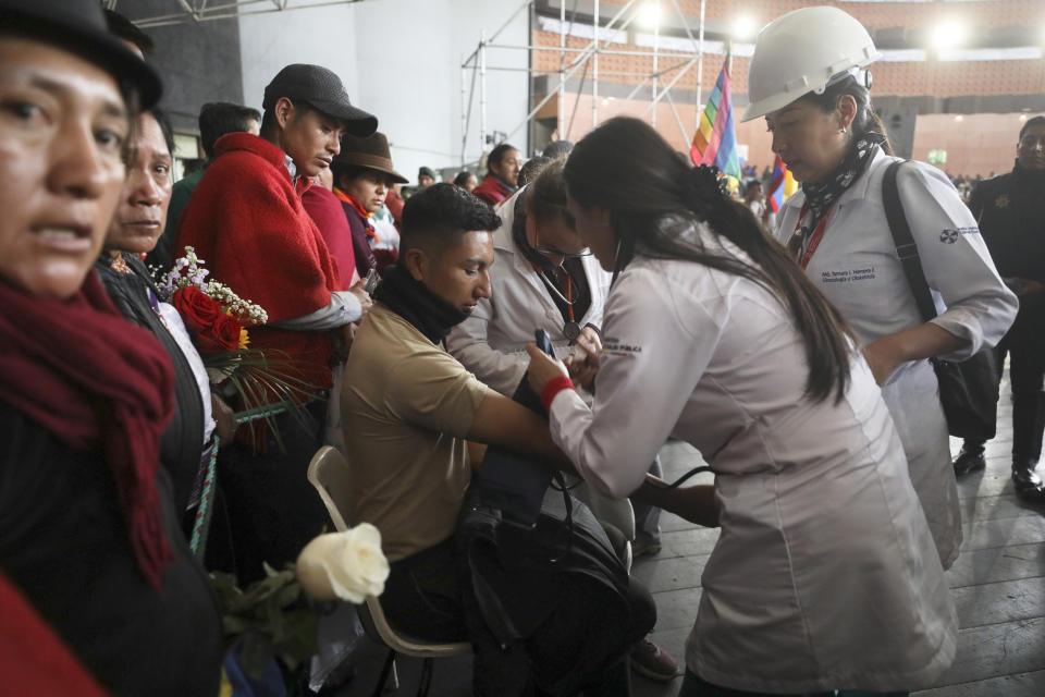 Doctors check the vitals one of several police officers detained by anti-government protesters at the Casa de Cultura in Quito, Ecuador, Thursday, Oct. 10, 2019. An indigenous leader and four other people have died in unrest in Ecuador since last week, the public defender's office said Thursday. (AP Photo/Fernando Vergara)