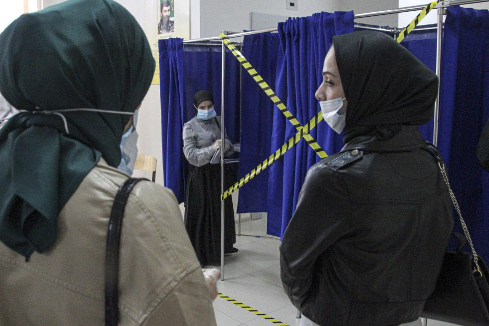 Chechen women wait to fill their ballots in a voting booth at a polling station during the Parliamentary elections in Grozny, Russia, Friday, Sept. 17, 2021. Russia has begun three days of voting for a new parliament that is unlikely to change the country's political complexion. There's no expectation that United Russia, the party devoted to President Vladimir Putin, will lose its dominance in the State Duma. (AP Photo/Musa Sadulayev)